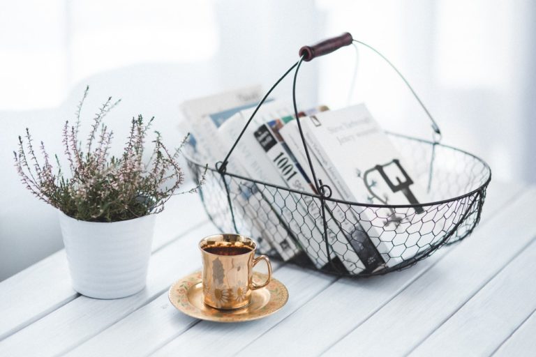 A basket with some magazines and a cup of coffee